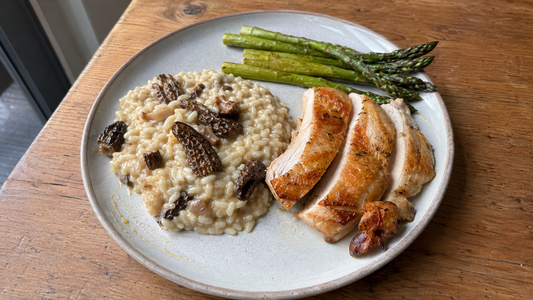Risotto aux morilles servi avec une volaille rôtie et des asperges vertes